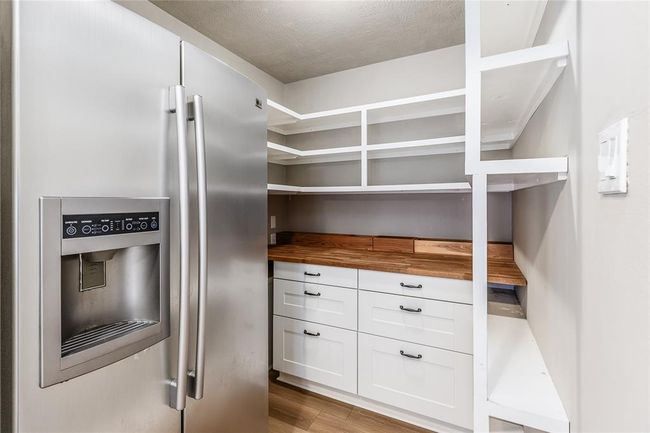 The butlers pantry adds more space for all of your snacks. There is also space for this secondary fridge that conveys with the home. | Image 18