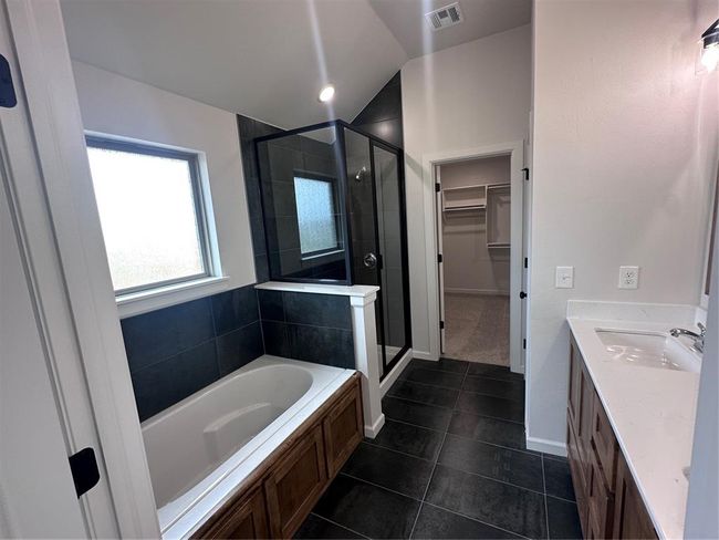Full bathroom featuring tile patterned flooring, a shower stall, a walk in closet, and visible vents | Image 6