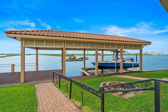 Follow the paver pathway to your large boathouse equipped with boat and jet ski lifts, along with dock space perfect for fishing, relaxing, and enjoying waterfront views | Image 41