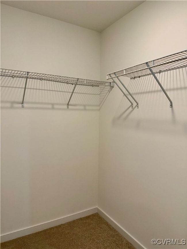 Walk in closet with dark colored carpet | Image 18