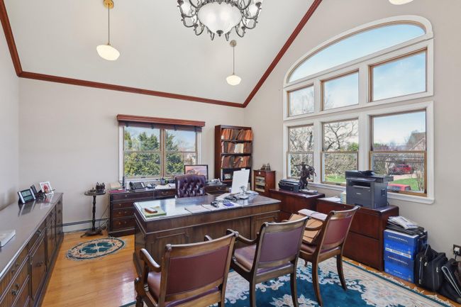 Home office with baseboard heating, crown molding, high vaulted ceiling, and light wood finished floors | Image 40