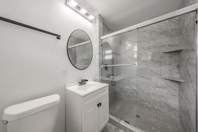 Bathroom featuring toilet, vanity, and a shower stall | Image 13