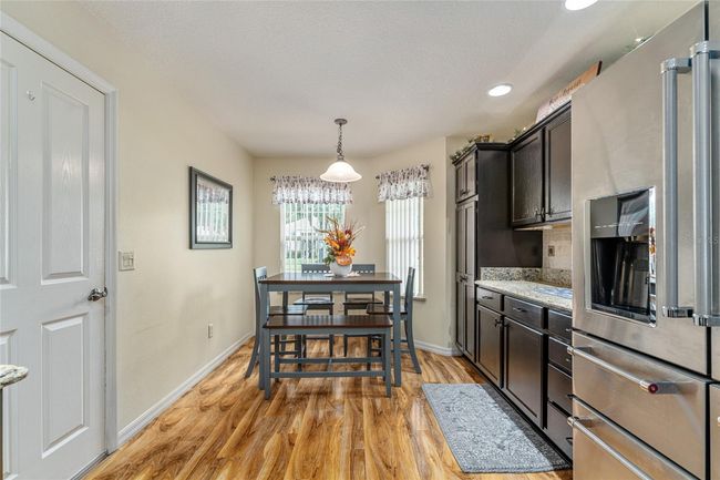 Eat-in kitchen with plenty of storage with roll out shelves, view to front yard and garage access. Table set is optional. | Image 7