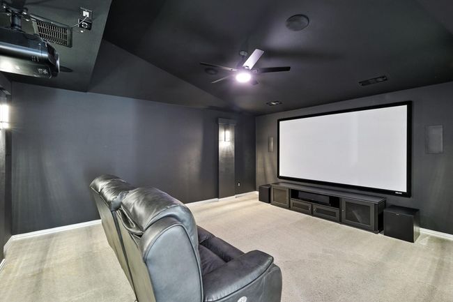 Cinema featuring ceiling fan, vaulted ceiling, and carpet flooring | Image 24