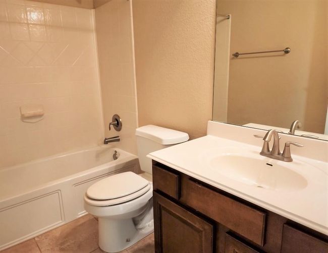 Bathroom with toilet, vanity, bathtub / shower combination, and tile patterned flooring | Image 28