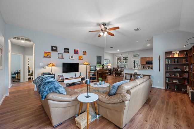 Living area featuring arched walkways, ceiling fan, wood finished floors, baseboards, and recessed lighting | Image 4