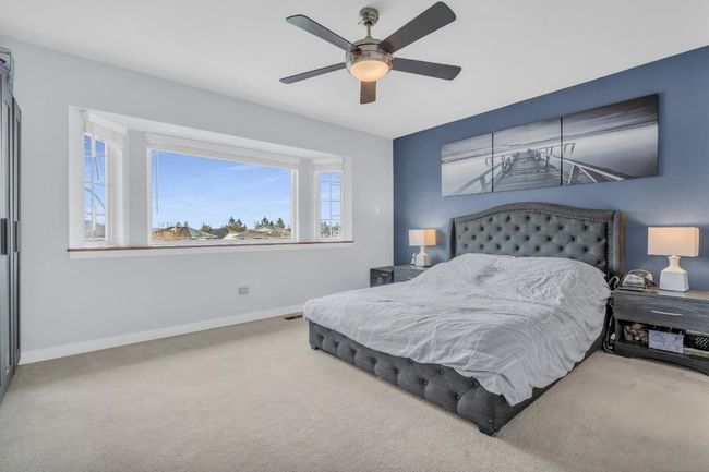 Carpeted bedroom with visible vents, baseboards, and ceiling fan | Image 20