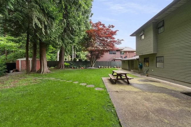 View of yard with an outbuilding, a patio area, fence, and a shed | Image 15
