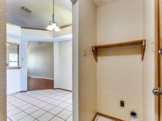 Washroom featuring a chandelier, tile patterned flooring, and a textured wall | Image 18