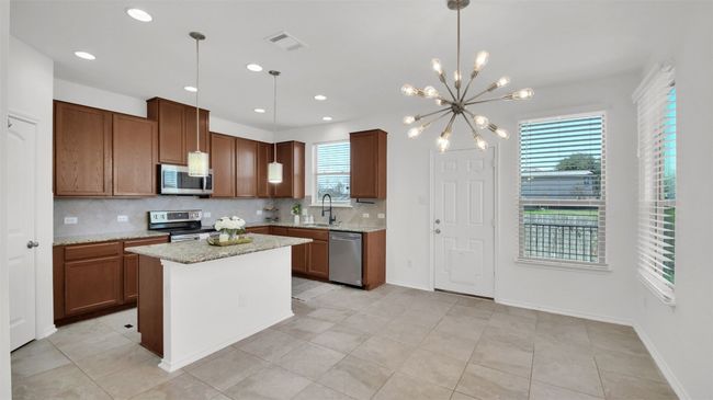 Kitchen featuring visible vents, decorative backsplash, appliances with stainless steel finishes, decorative light fixtures, and light stone​​‌​​​​‌​​‌‌​‌‌​​​‌‌​​‌‌​‌​​​​​‌ countertops | Image 11
