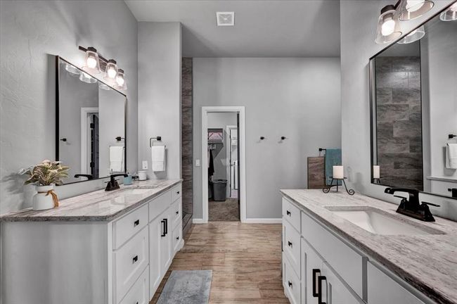 Bathroom featuring two vanities, wood finished floors, and baseboards | Image 29