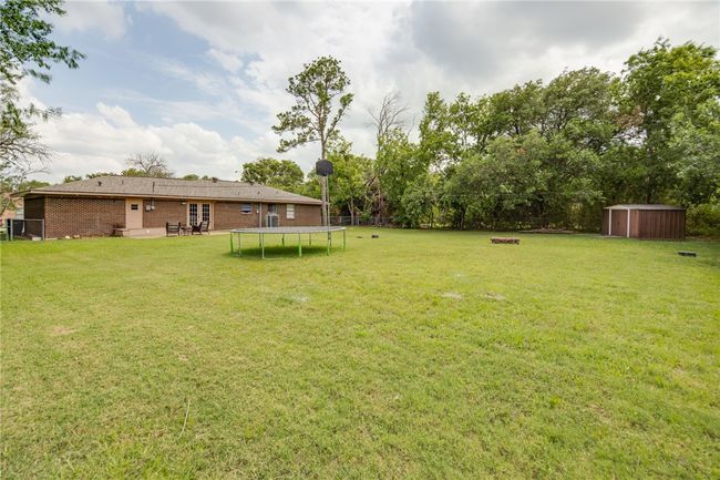 View of yard with a trampoline and a fire pit | Image 23