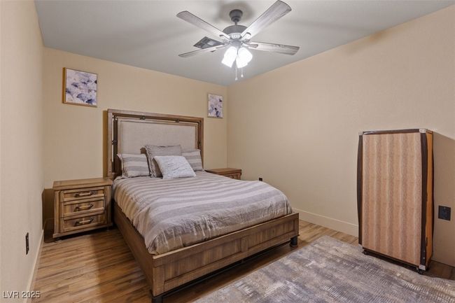 Bedroom with light wood-type flooring, ceiling fan, and baseboards | Image 51