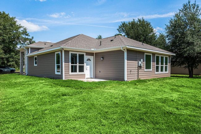 This is a modern, single-story home with a clean exterior, featuring multiple large windows and a well-maintained lawn. It’s surrounded by mature trees, offering a serene environment. | Image 41
