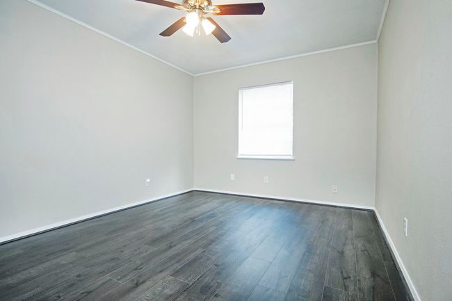 Spare room featuring ornamental molding, ceiling fan, and dark hardwood / wood-style floors | Image 23