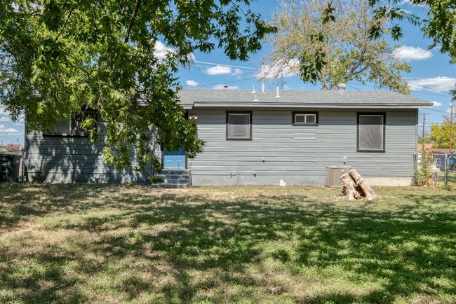 Back of house featuring entry steps, central AC unit, and a lawn | Image 21