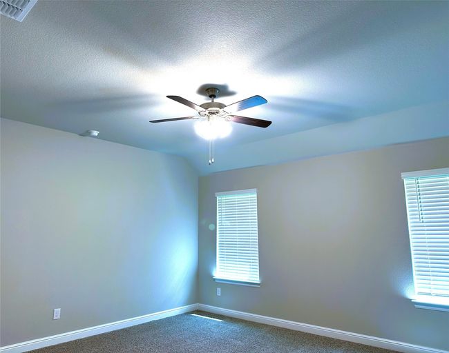 Spare room with dark colored carpet, ceiling fan, and a textured ceiling | Image 7