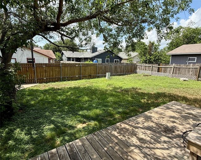 View of yard featuring a wooden deck and a residential view | Image 17