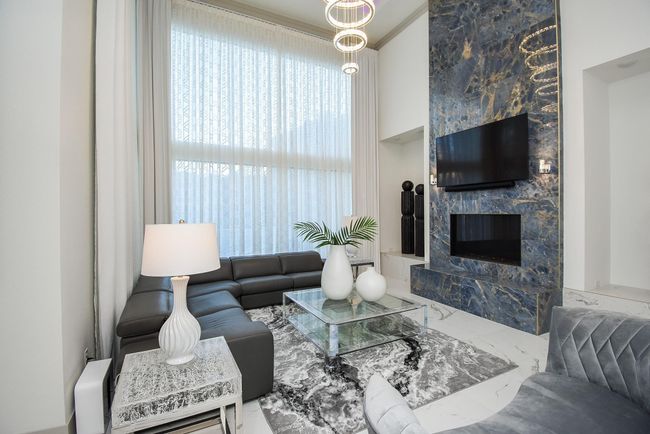 Beautiful living area features high ceilings, tall windows, showstopper fireplace and light fixture. | Image 10