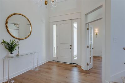 Entrance foyer with light hardwood / wood-style floors and a chandelier | Image 3