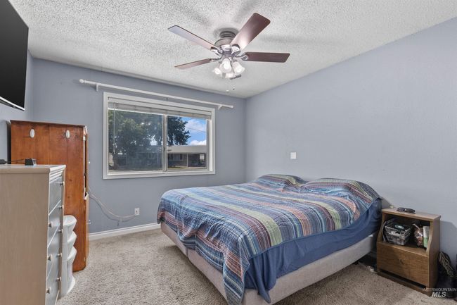 Carpeted bedroom with a textured ceiling and ceiling fan | Image 15