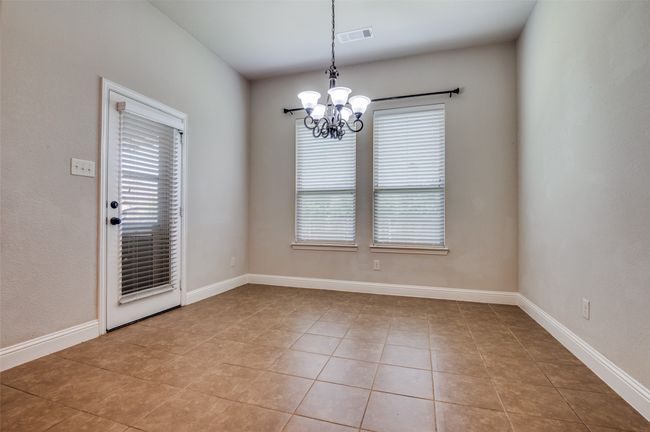 Spare room featuring healthy amount of natural light, a chandelier, and light tile patterned floors | Image 11
