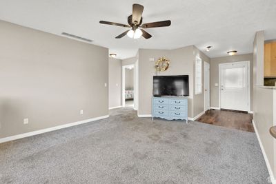 Living room with ceiling fan and light colored carpet | Image 3