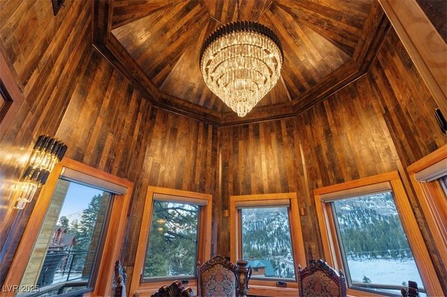 Interior details featuring an inviting chandelier and wooden walls | Image 37