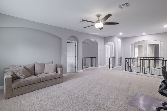 Living area featuring carpet floors, baseboards, a ceiling fan, recessed lighting, and arched walkways | Image 22