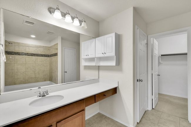 Full bath featuring tile patterned floors, baseboards, visible vents, and vanity | Image 24