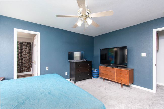Bedroom featuring a textured wall, carpet, baseboards, and a ceiling fan | Image 11