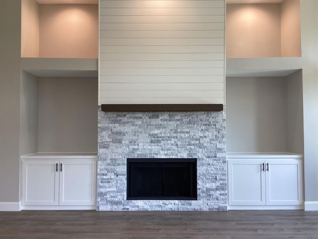 Detailed view of wood finished floors and a stone fireplace | Image 16