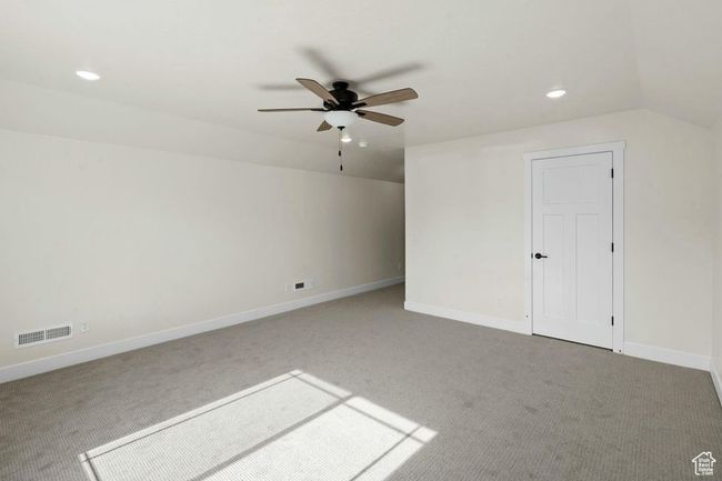 Bonus room featuring lofted ceiling, visible vents, carpet flooring, and ceiling fan | Image 33