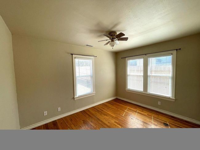 Empty room with baseboards, wood finished floors, and ceiling fan | Image 11
