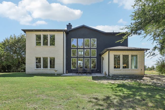 Rear view of house with brick siding, a chimney, a yard, and a patio area | Image 35