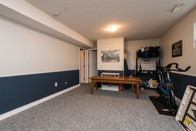 Interior space featuring carpet floors, a wainscoted wall, and visible vents | Image 23