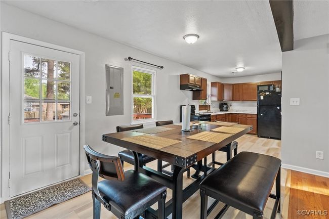 Dining room featuring light wood-style floors, electric panel, and baseboards | Image 15