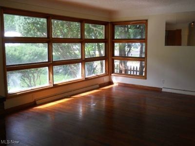 Empty room featuring a baseboard heating unit and dark hardwood / wood-style flooring | Image 3