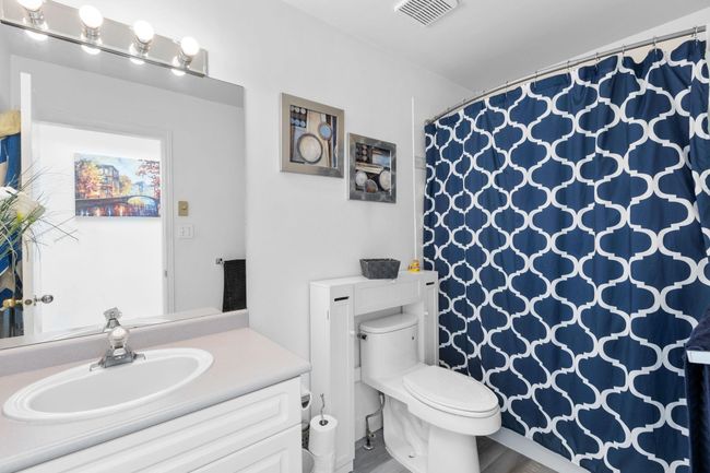 Full bath featuring vanity, curtained shower, and wood finished floors | Image 25