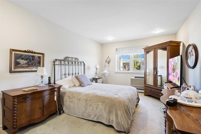 Bedroom with light colored carpet and a wall unit AC | Image 22