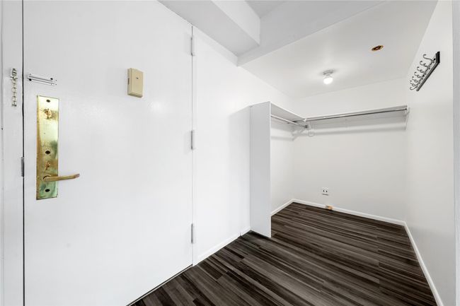 Walk in closet featuring dark wood finished floors | Image 7