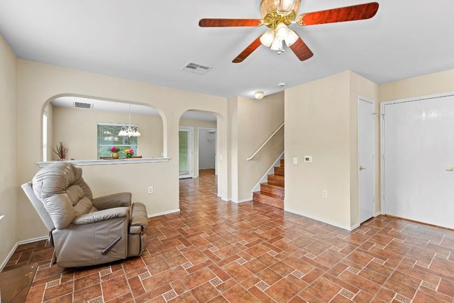 Sitting room featuring arched walkways, a ceiling fan, and stairs | Image 9