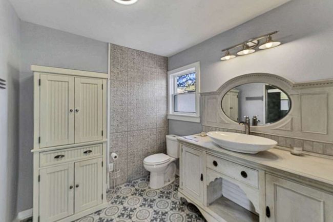 Bathroom featuring tile patterned flooring, vanity, tile walls, and toilet | Image 12