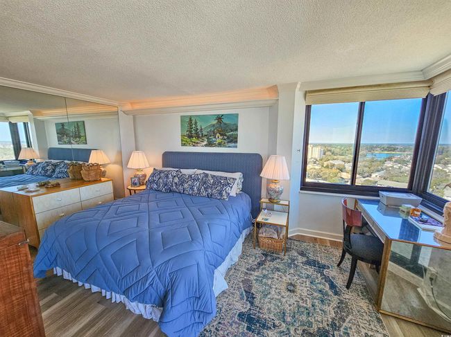 Bedroom featuring a textured ceiling, ornamental molding, baseboards, and wood finished floors | Image 22