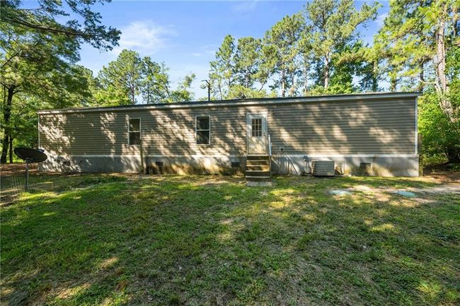Back of house featuring entry steps, a lawn, central AC unit, and crawl space | Image 32