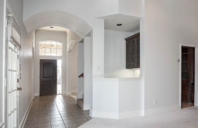 Tiled foyer entrance featuring baseboards, arched walkways, a high ceiling, and stairs | Image 11