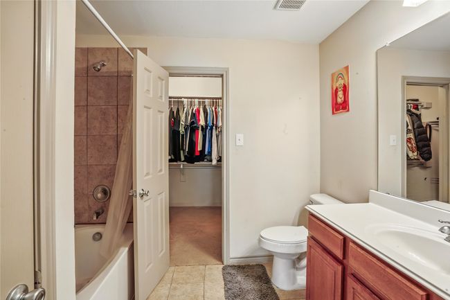 Bathroom featuring vanity, tile patterned flooring, tub / shower combination, and a spacious closet | Image 24