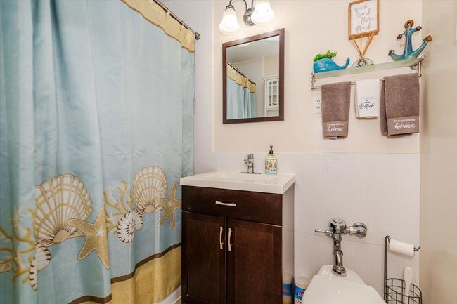 Full bathroom with vanity, a wainscoted wall, and curtained shower | Image 14