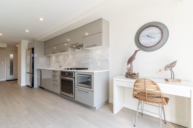 Kitchen featuring a sink, open floor plan, modern cabinets, gray cabinetry, and appliances with stainless steel finishes | Image 6