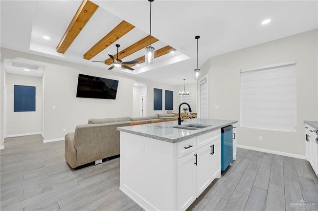 Kitchen featuring white cabinets, a ceiling fan, light wood-style tile flooring, and a sink | Image 10